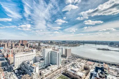 an aerial view of a city with a river and buildings at Blueground UES pool gym nr central park NYC-1293 in New York