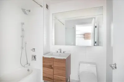 a white bathroom with a sink and a toilet at LES 1br w gym doorman wd nr park NYC-1314 in New York