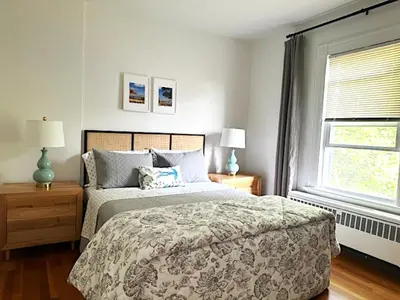 a bedroom with a bed and two lamps and a window at Sweet Escape, 2BR apt in BEACH community, Only 1 hr to NYC! in Norwalk