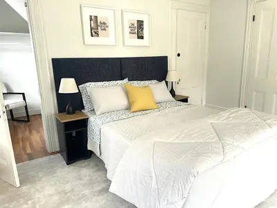 a bedroom with a large white bed with yellow pillows at Sweet Escape, 2BR apt in BEACH community, Only 1 hr to NYC! in Norwalk