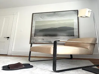 a chair in a room with a painting on the wall at Sweet Escape, 2BR apt in BEACH community, Only 1 hr to NYC! in Norwalk