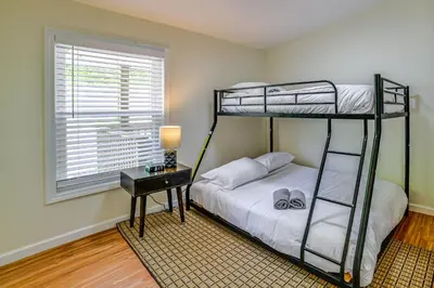 a bedroom with two bunk beds and a table at Nature Escape in Unadilla Modern Home with 2 Decks in Unadilla