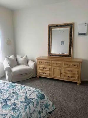 a bedroom with a dresser with a mirror and a couch at Renovated 3 bedroom for Professionals in Albany