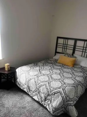 a bedroom with a black and white bed and a table at Renovated 3 bedroom for Professionals in Albany