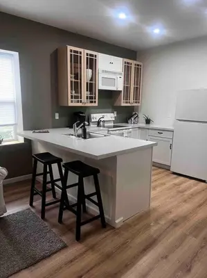 a kitchen with a sink and two bar stools at Renovated 3 bedroom for Professionals in Albany