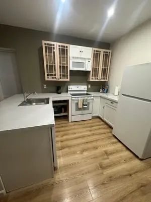 a kitchen with white appliances and wooden floors at Renovated 3 bedroom for Professionals in Albany