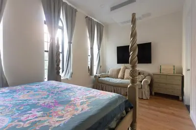 a bedroom with a bed and a couch and a tv at Little manhattan near Time Square in New York
