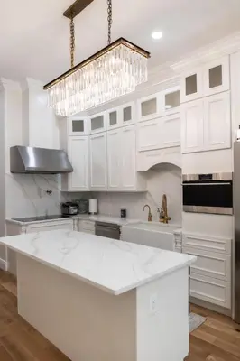 a kitchen with white cabinets and a chandelier at Little manhattan near Time Square in New York