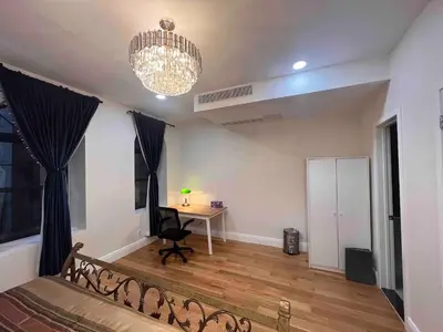 a bedroom with a bed and a desk and a chandelier at Little manhattan near Time Square in New York
