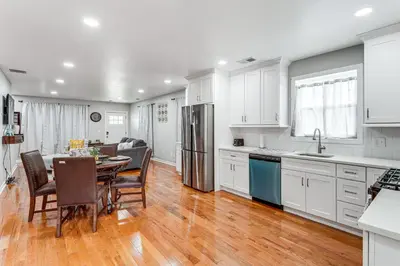 a kitchen and dining room with white cabinets and a table at 2 Mi to Dtwn Well-Appointed Bridgeport Duplex! in Bridgeport