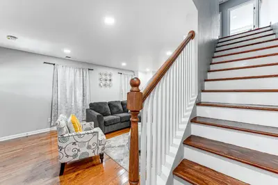 a living room with a staircase and a couch at 2 Mi to Dtwn Well-Appointed Bridgeport Duplex! in Bridgeport