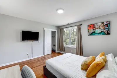 a bedroom with a bed and a flat screen tv at 2 Mi to Dtwn Well-Appointed Bridgeport Duplex! in Bridgeport