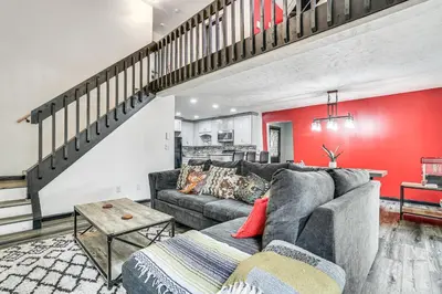 a living room with a gray couch and a red wall at Wooded Tobyhanna Home with Fire Pit and Lake Access! in Tobyhanna