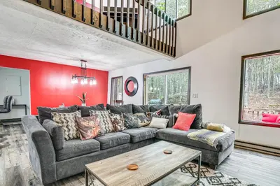 a living room with a couch and a table at Wooded Tobyhanna Home with Fire Pit and Lake Access! in Tobyhanna