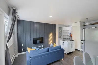 a living room with a blue couch and a tv at Lux Apt in Beacon