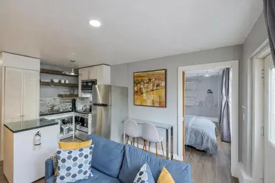 a living room with a blue couch and a kitchen at Lux Apt in Beacon