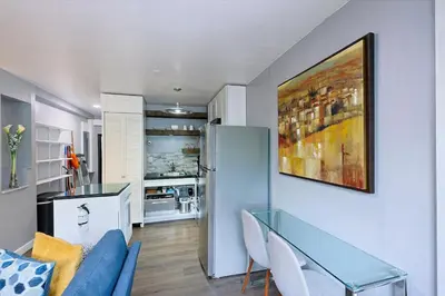 a living room with a glass table and a refrigerator at Lux Apt in Beacon