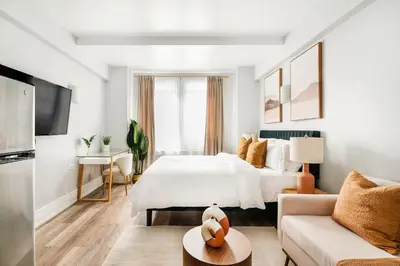 a white bedroom with a bed and a couch at 73-304 Newly Reno Studio UWS Doorman Gym Laundry in New York
