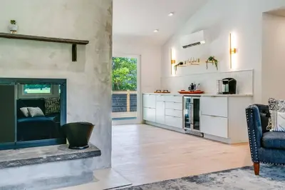 a living room with a fireplace and a chair at New Paltz Modern Zen Cabin in New Paltz