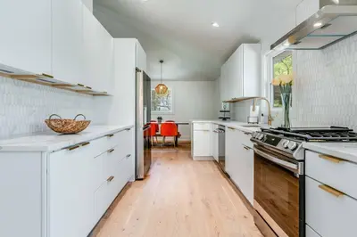 a kitchen with white cabinets and a stove top oven at New Paltz Modern Zen Cabin in New Paltz