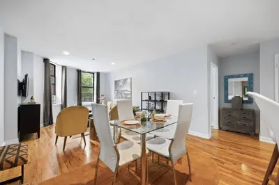 a dining room and living room with a table and chairs at The Lenox in New York