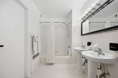 a white bathroom with a sink and a shower at Harlem Renaissance in New York