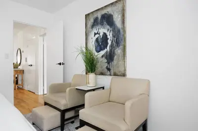 a living room with two chairs and a table and a painting at Harlem Renaissance in New York