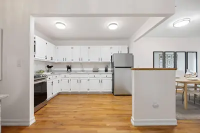 a kitchen with white cabinets and a refrigerator at Harlem Renaissance in New York