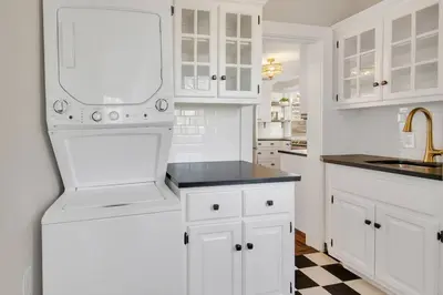a white kitchen with white cabinets and a checkered floor at Prime West Hartford Center- Timeless Charm in West Hartford