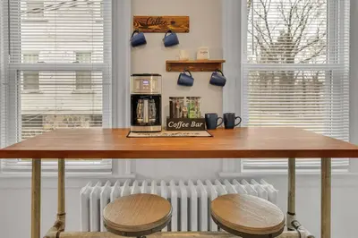 a table with two chairs and a coffee bar at Classic West Hartford Center Apartment in West Hartford