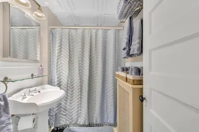 a bathroom with a sink and a shower curtain at Classic West Hartford Center Apartment in West Hartford