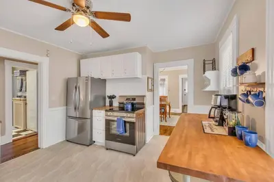 a kitchen with a stainless steel refrigerator and a ceiling fan at Classic West Hartford Center Apartment in West Hartford