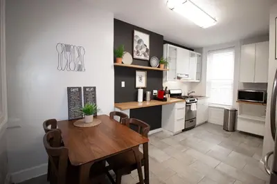 a kitchen with a wooden table and a dining room at Hoboken 15 Min Train to Manhattan Full Kitchen in Hoboken