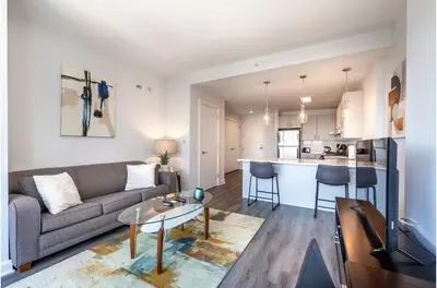a living room and kitchen with a couch and a table at Private Apt with Gym & Pool in Stamford