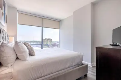a bedroom with a large bed with a large window at Private Apt with Gym & Pool in Stamford