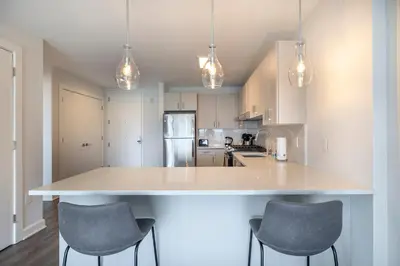 a kitchen with a large island with three chairs around it at Private Apt with Gym & Pool in Stamford