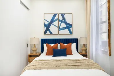 a bedroom with a bed with orange and blue pillows at 317-1D New 2BR Duplex WD Private Backyard in New York