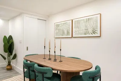 a dining room with a wooden table and green chairs at 317-1D New 2BR Duplex WD Private Backyard in New York