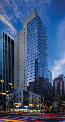 a tall glass building with a street in front of it at Beautiful Resort in Midtown 45 - Deluxe 1BD in New York