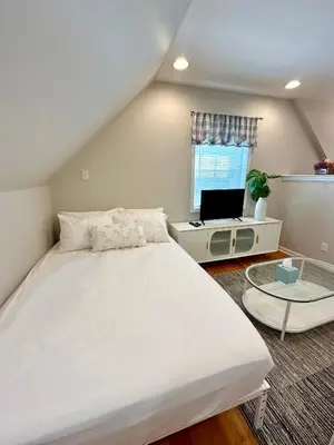 a bedroom with a bed and a desk with a laptop at Cozy studio quiet in Trumbull