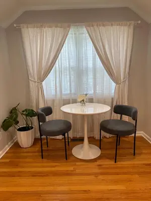 a table and chairs in a room with a window at Cozy studio quiet in Trumbull