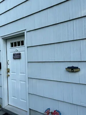 a door to a house with a surfboard next to it at Cozy studio quiet in Trumbull