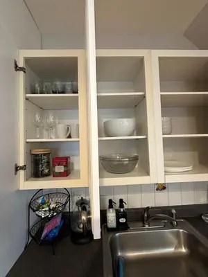 a kitchen with a sink and a cabinet with dishes at Cozy studio quiet in Trumbull