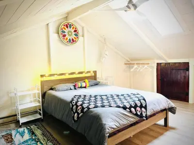 a bedroom with a bed with a clock on the wall at Catskill Cabin, Cool Apartment, 2nd Floor in Shandaken