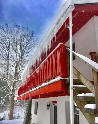 a building with a red roof with snow on it at Catskill Cabin, Cool Apartment, 2nd Floor in Shandaken