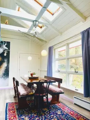 a dining room with a table and chairs and windows at Catskill Cabin, Cool Apartment, 2nd Floor in Shandaken