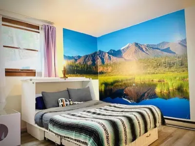 a bedroom with a large painting of a lake and mountains at Catskill Cabin, Chill Apartment, 1st Fl in Shandaken