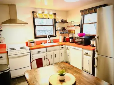 a kitchen with white appliances and a wooden table at Catskill Cabin, Chill Apartment, 1st Fl in Shandaken