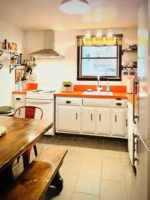 a kitchen with white cabinets and a wooden table at Catskill Cabin, Chill Apartment, 1st Fl in Shandaken