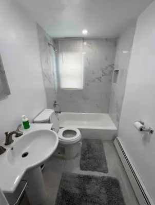 a white bathroom with a sink and a toilet at Cozy Apartment 2 BedroomS in Hillside